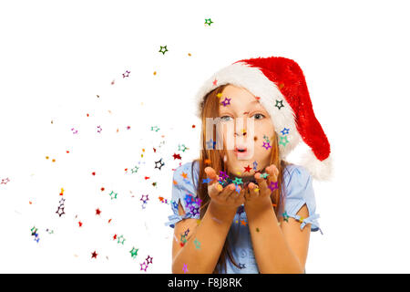 Ragazza soffia confetti di palme di Santa hat Foto Stock