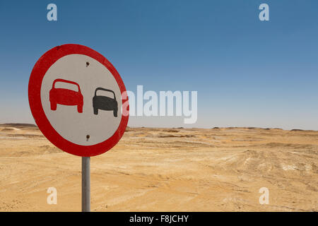 Una singola nessun sorpasso circular road sign con bordo rosso su una strada nel deserto a sinistra dell'immagine Foto Stock