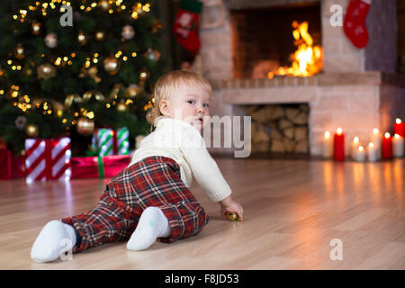 Kid strisciare per doni sdraiati sotto l albero di Natale Foto Stock