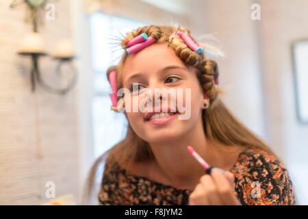 Adolescente mettendo sul make-up nella stanza da bagno Foto Stock