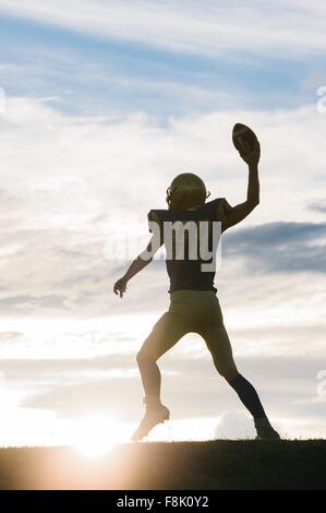 Giovane giocatore di football americano che sta per lanciare la sfera Foto Stock