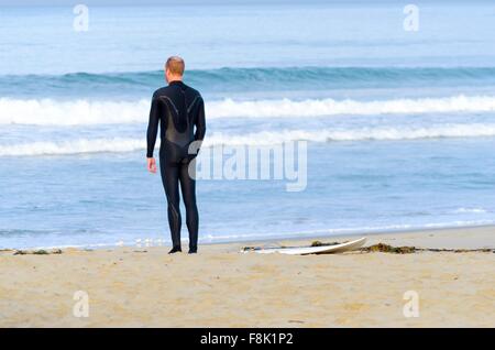 Un Americano surfer boy in Pacific Beach a San Diego, la California del Sud, negli Stati Uniti d'America in piedi sul g Foto Stock