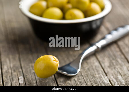 Olive verdi snocciolate sul tavolo di legno Foto Stock