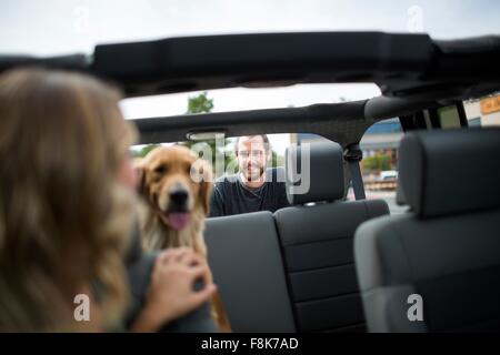 Giovane donna in jeep guardando sopra la sua spalla nel cane e ragazzo Foto Stock