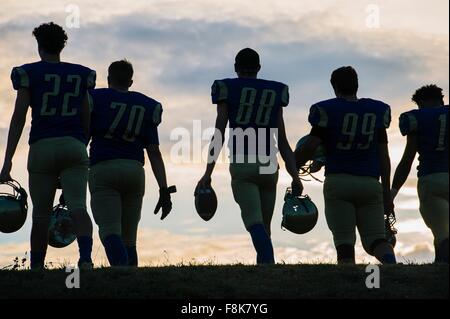 Gruppo di giovani american football giocatori a piedi, vista posteriore Foto Stock