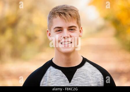 Testa e la spalla ritratto di ragazzo adolescente nella foresta di autunno Foto Stock