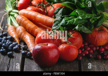 Assortimento di frutta fresca, verdura e bacche di carote, spinaci, i pomodori, le mele rosse, mirtilli e mirtilli rossi sopra il vecchio w Foto Stock