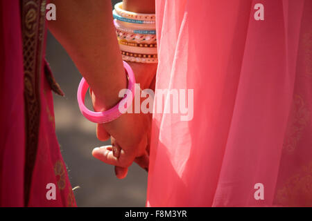 PUSHKAR, INDIA - NOV 28: Close up dettaglio delle mani di due indiani ragazza con velo di colore rosa, mano nella mano a camminare in Pushkar, India, Foto Stock