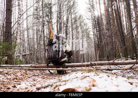 Vista posteriore dei maschi di un escursionista in coperta di neve foresta con le racchette da neve in uno zaino, Ural, Russia Foto Stock