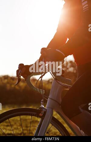 Ciclista in sella durante il tramonto Foto Stock