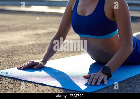 Vista ritagliata della giovane donna a praticare yoga in ambiente urbano parcheggio Foto Stock