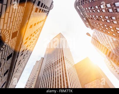 Basso angolo di vista ufficio soleggiato grattacieli di Manhattan il quartiere finanziario di New York, Stati Uniti d'America Foto Stock