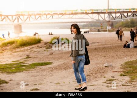 Metà donna adulta guardando sopra la spalla Foto Stock