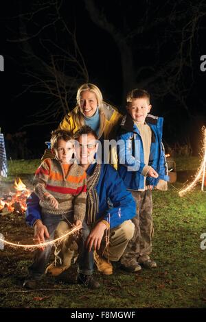 Fratelli in posa con botti sulla notte dei falò con i loro genitori Foto Stock