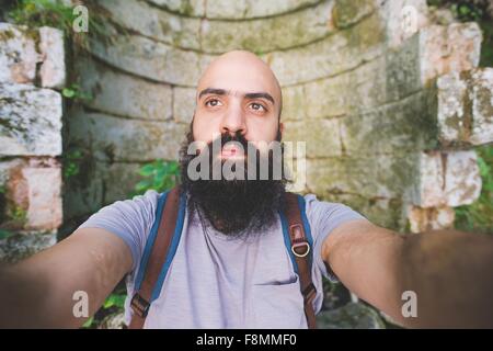 Uomo Barbuto in posa contro il vecchio muro di mattoni, Garda, Italia Foto Stock