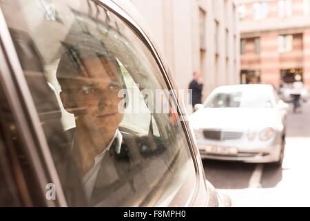 Imprenditore guardando fuori i taxi neri di Londra, Regno Unito Foto Stock