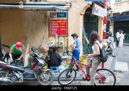 Il vietnamita ladies cucinare e servire il cibo su un angolo di strada in Hanoi old quarter,Vietnam,Asia Foto Stock