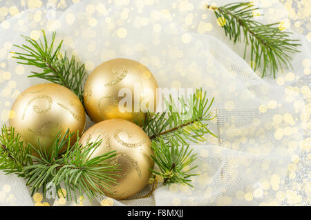 Dorata Ornamenti natale su un abete del ramo Foto Stock