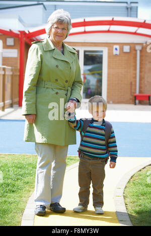 Nonna tenendo il nipote a scuola Foto Stock