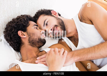 Felice coppia gay posa sul letto Foto Stock