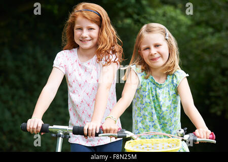 Due ragazze giocando sulla moto e scooter all'aperto Foto Stock