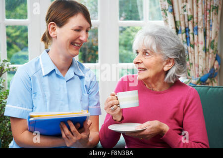 Senior donna di essere visitata da accompagnatore a casa Foto Stock