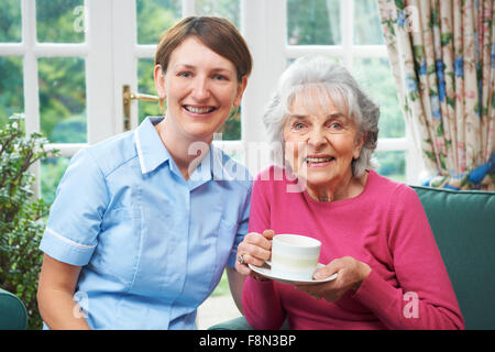 Senior donna di essere visitata da accompagnatore a casa Foto Stock