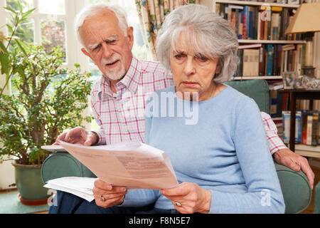 Coppia senior passando attraverso le finanze guardando preoccupato Foto Stock