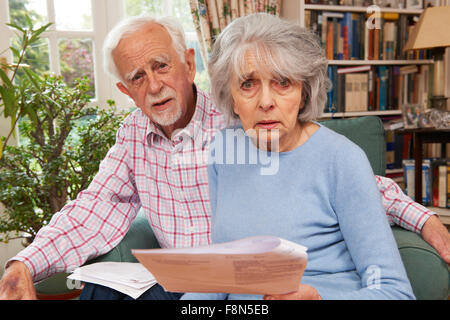 Coppia senior passando attraverso le finanze guardando preoccupato Foto Stock