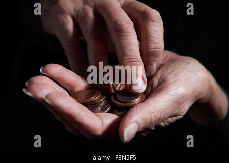 Senior donna contare monete in mano Foto Stock