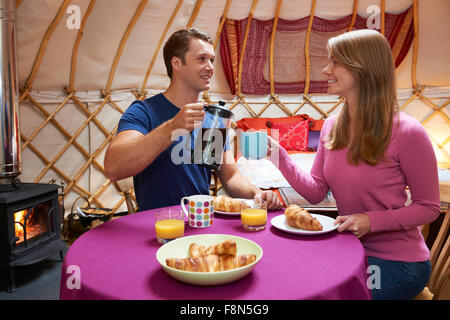 Giovane gustando la prima colazione mentre il campeggio In yurta tradizionali Foto Stock