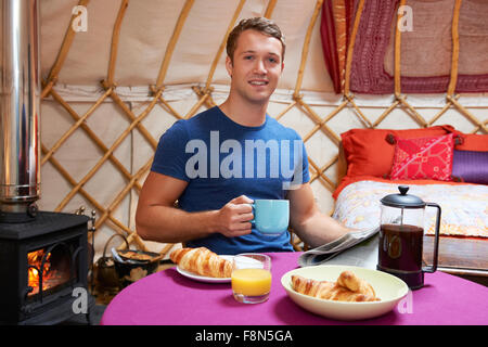 L'uomo gustando la prima colazione mentre il campeggio In yurta tradizionali Foto Stock