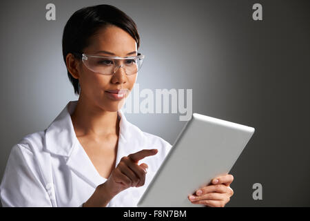 Ritratto in studio di laboratorio femmina lavoratore con tavoletta digitale Foto Stock