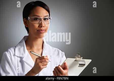 Donna scienziato iscritto negli appunti Foto Stock