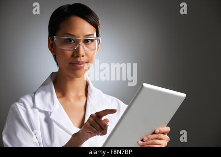 Ritratto in studio di laboratorio femmina lavoratore con tavoletta digitale Foto Stock