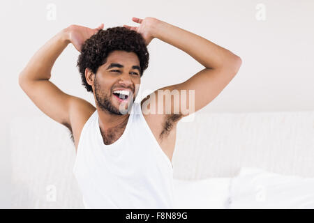 Attraente uomo su letto di ridere Foto Stock