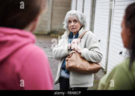 Senior sentimento donna intimidire da ragazze adolescenti Foto Stock