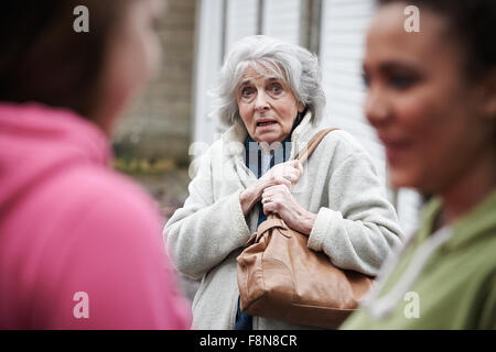 Senior sentimento donna intimidire da ragazze adolescenti Foto Stock