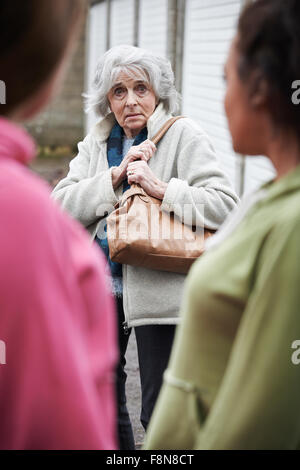 Senior sentimento donna intimidire da ragazze adolescenti Foto Stock