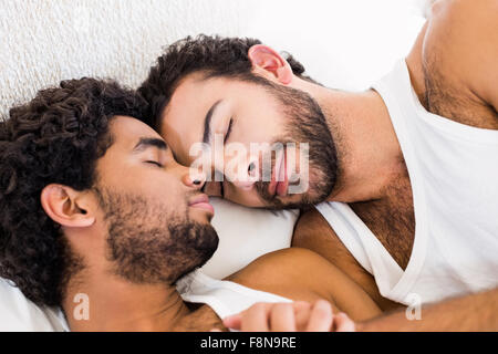 Felice coppia gay dormire insieme sul letto Foto Stock