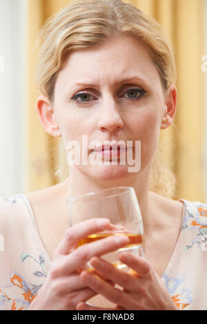 Donna che mantiene un bicchiere di Whiskey Foto Stock