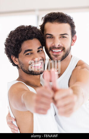 Sorridente coppia gay che mostra thmbs fino Foto Stock