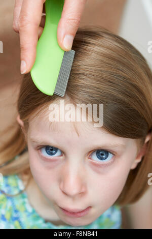 Madre controllo figlie per capelli pidocchio della testa Foto Stock