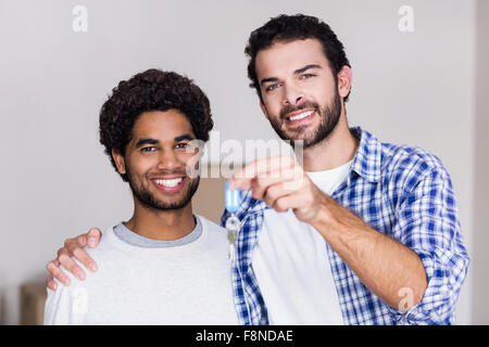 Felice coppia gay azienda nuove chiavi di casa Foto Stock