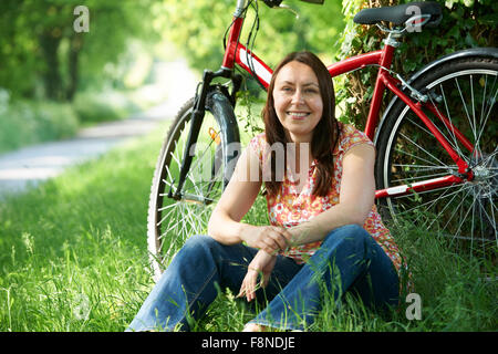 Donna di mezza età in giro in bicicletta in campagna Foto Stock