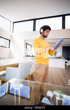 Uomo sorridente con tablet e cuffie Foto Stock