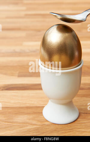 Cracking cucchiaio Golden Egg Foto Stock