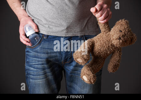 Padre tenendo il biberon e Orsacchiotto Foto Stock