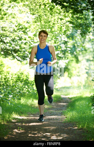 Donna di mezza età in esecuzione in campagna Foto Stock