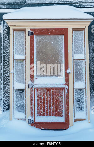 Vecchia porta e porta dello schermo dopo una nevicata. Foto Stock